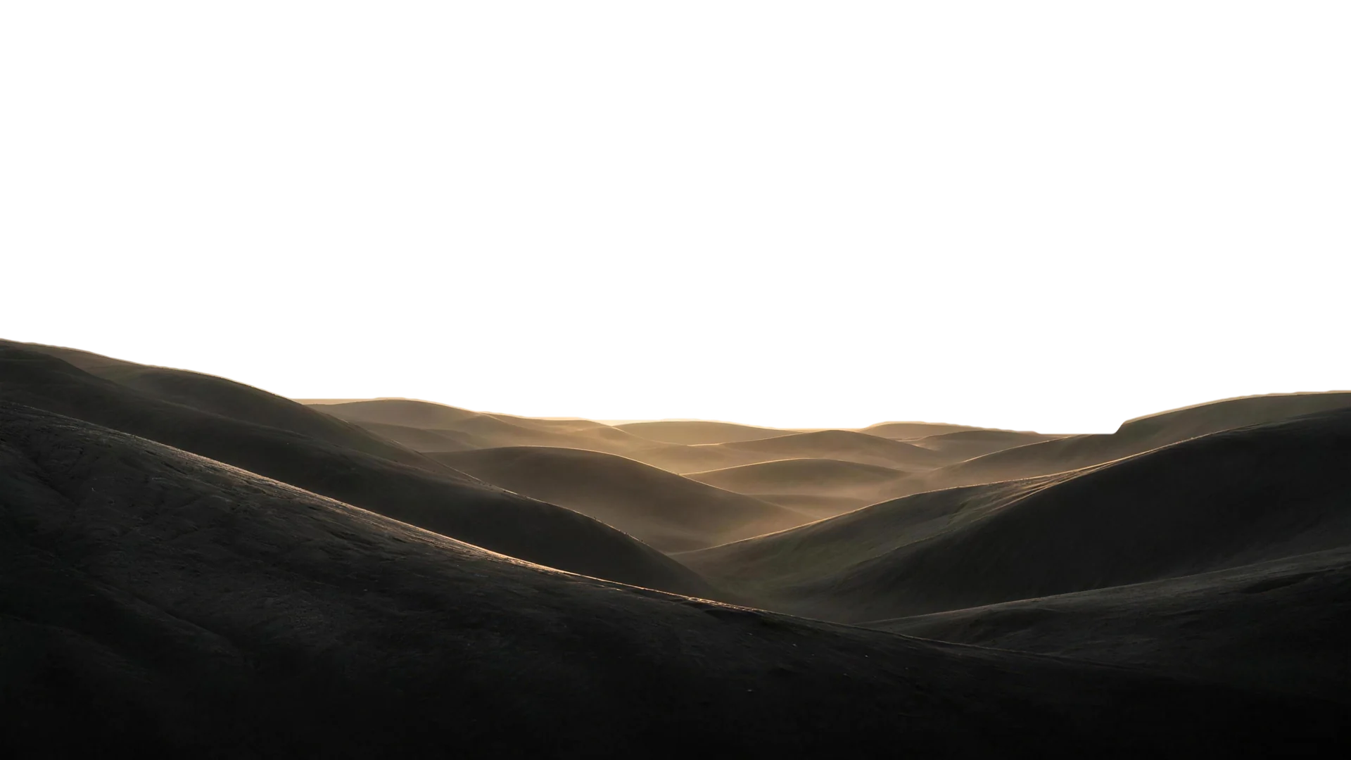 Dark slate dunes as the sun rises and brightens until the frame washes to cream